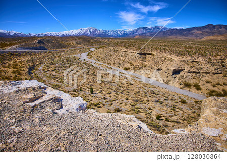 Desert and Snow-Capped Mountains Panorama with Dry Riverbed Motion 128030864