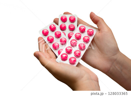 Hand holding blister pack of pink pills Hand holding blister pack of pink pills 128033365