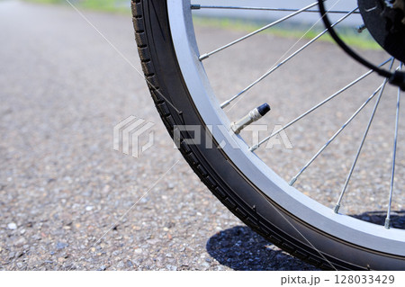 路面と自転車のタイヤ空気圧と英式バルブ 128033429