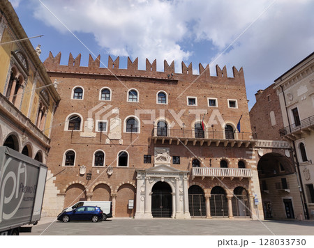 Verona, Italy - May 12, 2025: Palazzo della ragione and torre dei lamberti dominate piazza delle erbe under a cloudy sky in verona, italy Verona, Italy - May 12, 2025: Palazzo della ragione and torre dei lamberti dominate piazza delle erbe under a cloudy sky in verona, italy 128033730