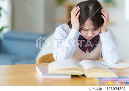 自宅で勉強中に悩む女子高生 128034201