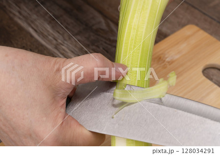 野菜コンソメスープを作る工程　野菜を刻み煮込む　セロリの筋,取る 128034291