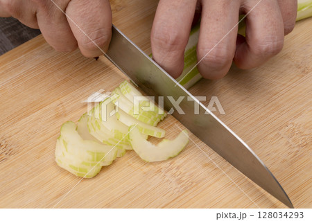 野菜コンソメスープを作る工程　野菜を刻み煮込む　セロリを小口切りにする 128034293