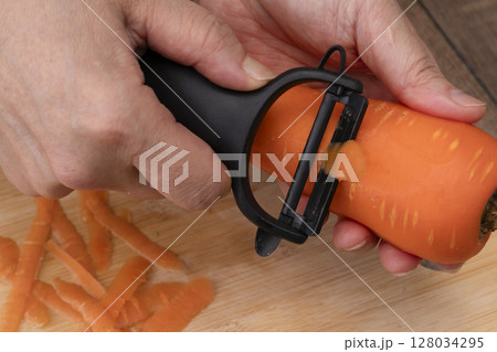 野菜コンソメスープを作る工程 野菜を刻み煮込む 人参の皮をピーラーで剥く 野菜コンソメスープを作る工程 野菜を刻み煮込む 人参の皮をピーラーで剥く 128034295