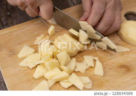 野菜コンソメスープを作る工程　野菜を刻み煮込む　じゃがいもをいちょう切りにする 128034309