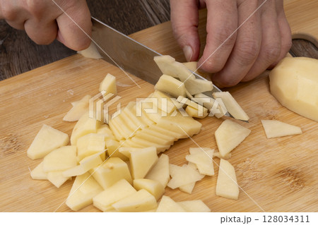 野菜コンソメスープを作る工程　野菜を刻み煮込む　じゃがいもをいちょう切りにする 128034311