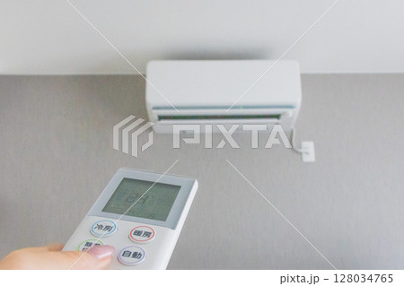 エアコンのリモコンを操作する手 128034765