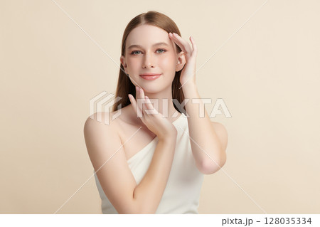 A beautiful young woman with clean, fresh skin against a beige background. Skincare, facial treatment, cosmetology, beauty, and spa. An elegant portrait of an woman. A beautiful young woman with clean, fresh skin against a beige background. Skincare, facial treatment, cosmetology, beauty, and spa. An elegant portrait of an woman. 128035334