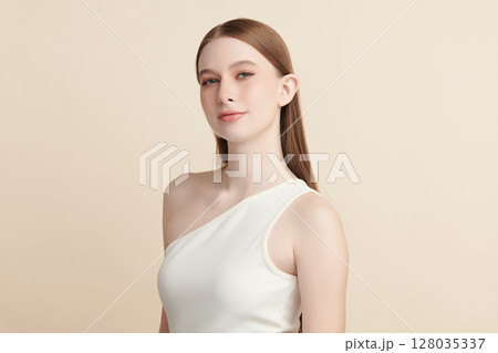 A beautiful young woman with clean, fresh skin against a beige background. Skincare, facial treatment, cosmetology, beauty, and spa. An elegant portrait of an woman. A beautiful young woman with clean, fresh skin against a beige background. Skincare, facial treatment, cosmetology, beauty, and spa. An elegant portrait of an woman. 128035337