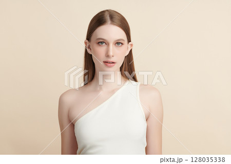 A beautiful young woman with clean, fresh skin against a beige background. Skincare, facial treatment, cosmetology, beauty, and spa. An elegant portrait of an woman. A beautiful young woman with clean, fresh skin against a beige background. Skincare, facial treatment, cosmetology, beauty, and spa. An elegant portrait of an woman. 128035338