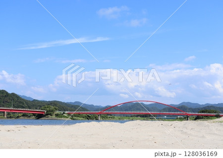 青空の下に朱塗りの長い歩道橋が鮮やかな岸田川河口 128036169