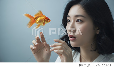 空中を泳ぐ金魚に触れようとする女性 128036484