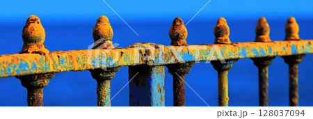 Rusty Metal Fence Blue Ocean Background Vintage Texture Weathered Iron Railing Old Grunge Fence Post 128037094