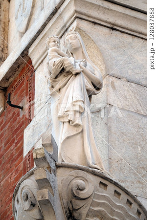 Statue of the Virgin Mary with baby Jesus on the house facade in Lucca, Tuscany, Italy 128037888