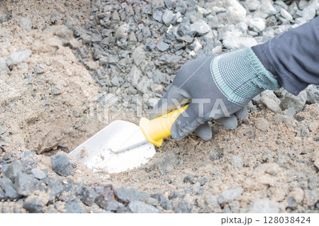 穴を掘る男性の手元 128038424