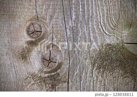 Detailed image of textured weathered wood showing knots and cracks in a close-up view. 128038811