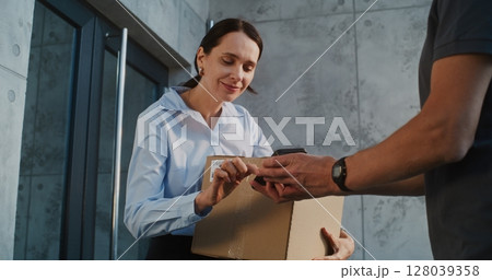 Businesswoman Receiving Package with Online Shopping Order, Signing POD on Smartphone 128039358