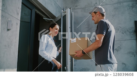 Businesswoman Receiving Her Package from Postal Service Worker, Signing POD on Tablet Computer 128039608