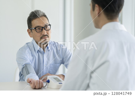 血圧測定を受ける50代後半の男性 血圧測定を受ける50代後半の男性 128041749
