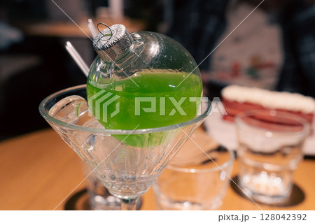 Green cocktail on a wooden table Green cocktail on a wooden table 128042392