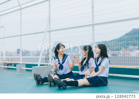 校舎の屋上で談笑する女子高生3人組　 128042773