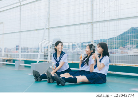 校舎の屋上で談笑する女子高生3人組 校舎の屋上で談笑する女子高生3人組 128042774