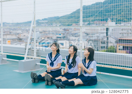 校舎の屋上で談笑する女子高生3人組　 128042775