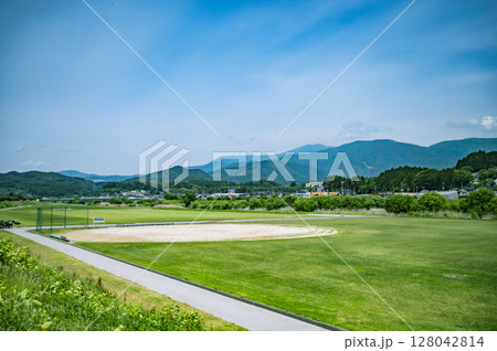 青空と山並みの広がる河川敷公園の野球場 128042814