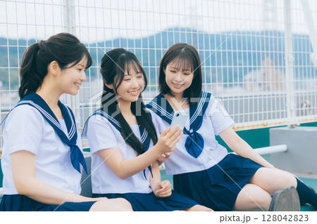 屋上でスマホを見る女子高生 128042823