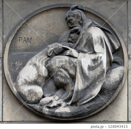 The story of Pan, the god of the wild, shepherds and flocks. Stone relief at the building of the Faculte de Medicine Paris, France. 128043413