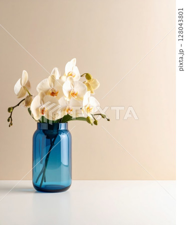 Pink orchid flowers in a glass vase on a table, a beautiful spring nature decoration 128043801