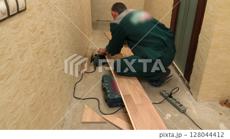Carpenter worker cutting wooden panel with jig saw timelapse 128044412