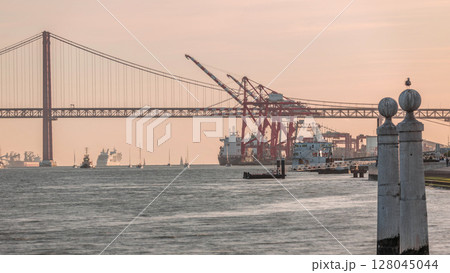 Cais das Colunas near Cais do Sodre timelapse with 25 April Bridge and cargo port terminal. Lisbon, Portugal Cais das Colunas near Cais do Sodre timelapse with 25 April Bridge and cargo port terminal. Lisbon, Portugal 128045044