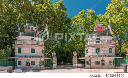 Timelapse hyperlapse of Lisbon Zoo entrance with open gates and flags on towers during summer. Lisbon, Portugal 128045101