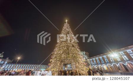 Commerce Square in Lisbon illuminated at Christmas hyperlapse, with a towering tree and crowds celebrating at night. Portugal 128045107