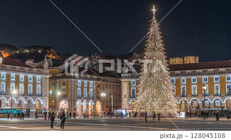 Commerce Square in Lisbon illuminated at Christmas hyperlapse, with a towering tree and crowds celebrating at night. Portugal 128045108
