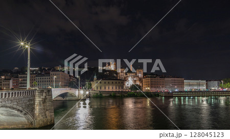Panorama showing night timelapse of Lyon's cityscape with the red suspension footbridge over the Saone River. France Panorama showing night timelapse of Lyon's cityscape with the red suspension footbridge over the Saone River. France 128045123