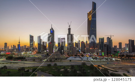 Skyline with Skyscrapers day to night timelapse in Kuwait City downtown illuminated at dusk. Kuwait City, Middle East 128045175