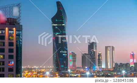 Skyline with Skyscrapers day to night timelapse in Kuwait City downtown illuminated at dusk. Kuwait City, Middle East 128045186