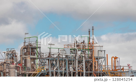 Distillation Columns and their process equipment of hydrogen plant timelapse with clouds on a background. 128045254