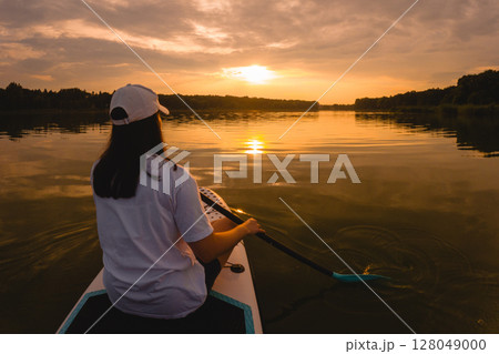 Paddleboarding at Sunset on a Calm Lake 128049000