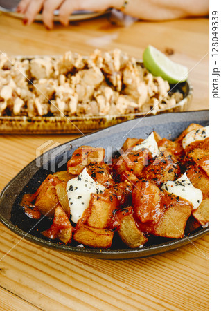 patatas bravas and chipirones on wooden table patatas bravas and chipirones on wooden table 128049339