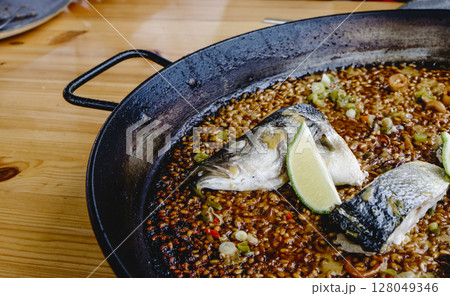 sea bass paella in the cooking pan 128049346