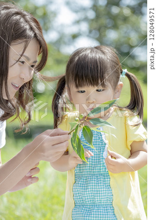 公園でどんぐりを見つめる母と娘 128049571