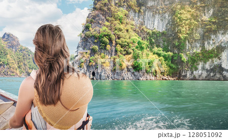 Serene Escape - Female Traveler Admires Emerald Waters of Cheow Lan Lake in Khao Sok National Park, Thailand Close-Up Rear View of Boat Journey 128051092