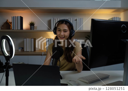 Digital Content Creation. Young woman in headphones animatedly discussing with her audience. 128051251