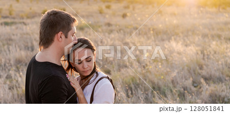 Man and a woman are hugging in a field 128051841