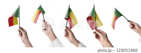 The Benin flag in hand in different angles on a white background The Benin flag in hand in different angles on a white background 128051960