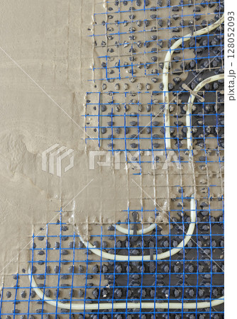 Liquid concrete is poured over floor heating installation in a new building. Modern construction system Liquid concrete is poured over floor heating installation in a new building. Modern construction system 128052093