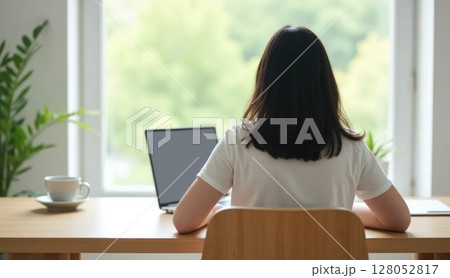 Person working at minimalist home office desk, back view Person working at minimalist home office desk, back view 128052817